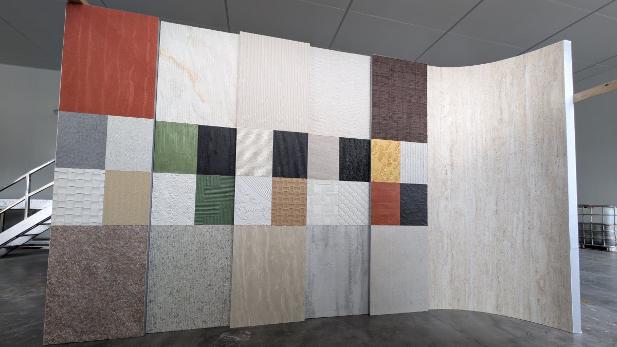Curved wall displaying Angtai's colorful, textured stone samples at Marmomac 2025