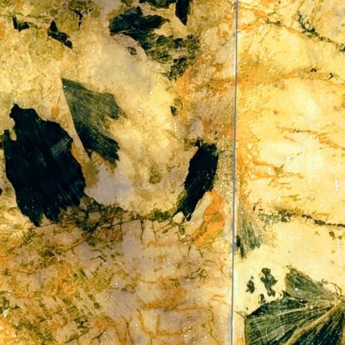 chiseled stone with intricate beige, black, and orange patterns under natural light