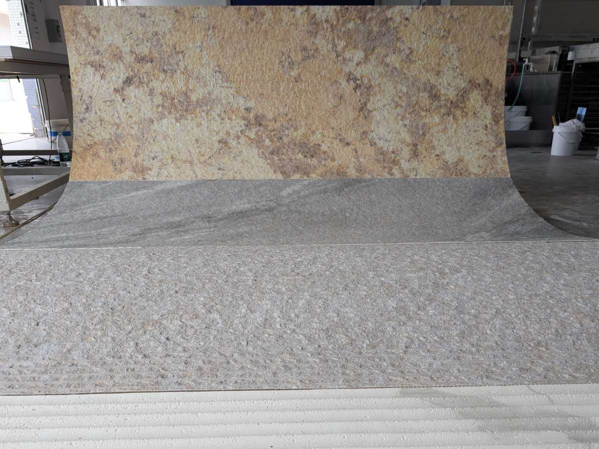 Flexible stone sheet standing upright in workshop, displaying natural texture and pliability.